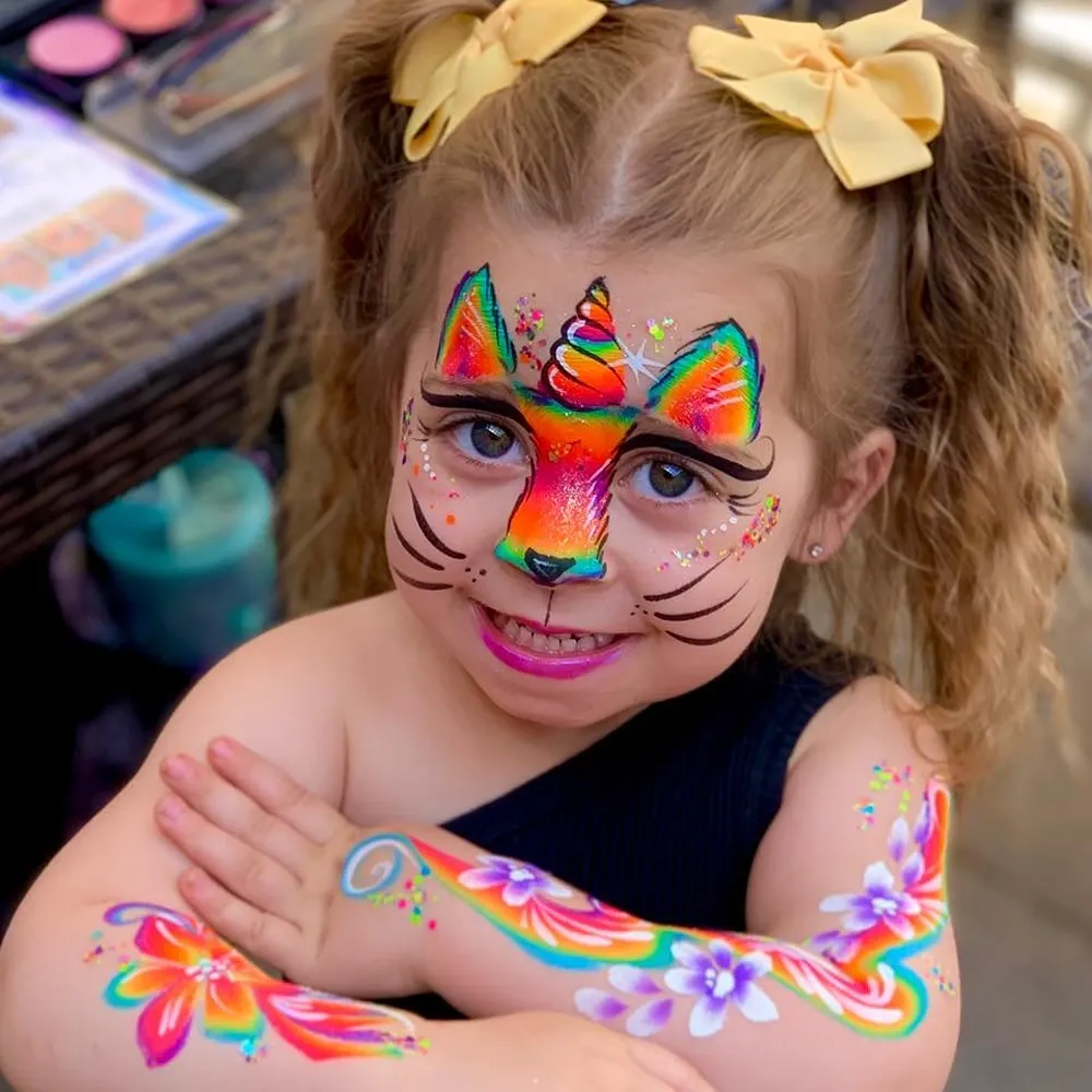 girl with rainbow cat face and arm paint