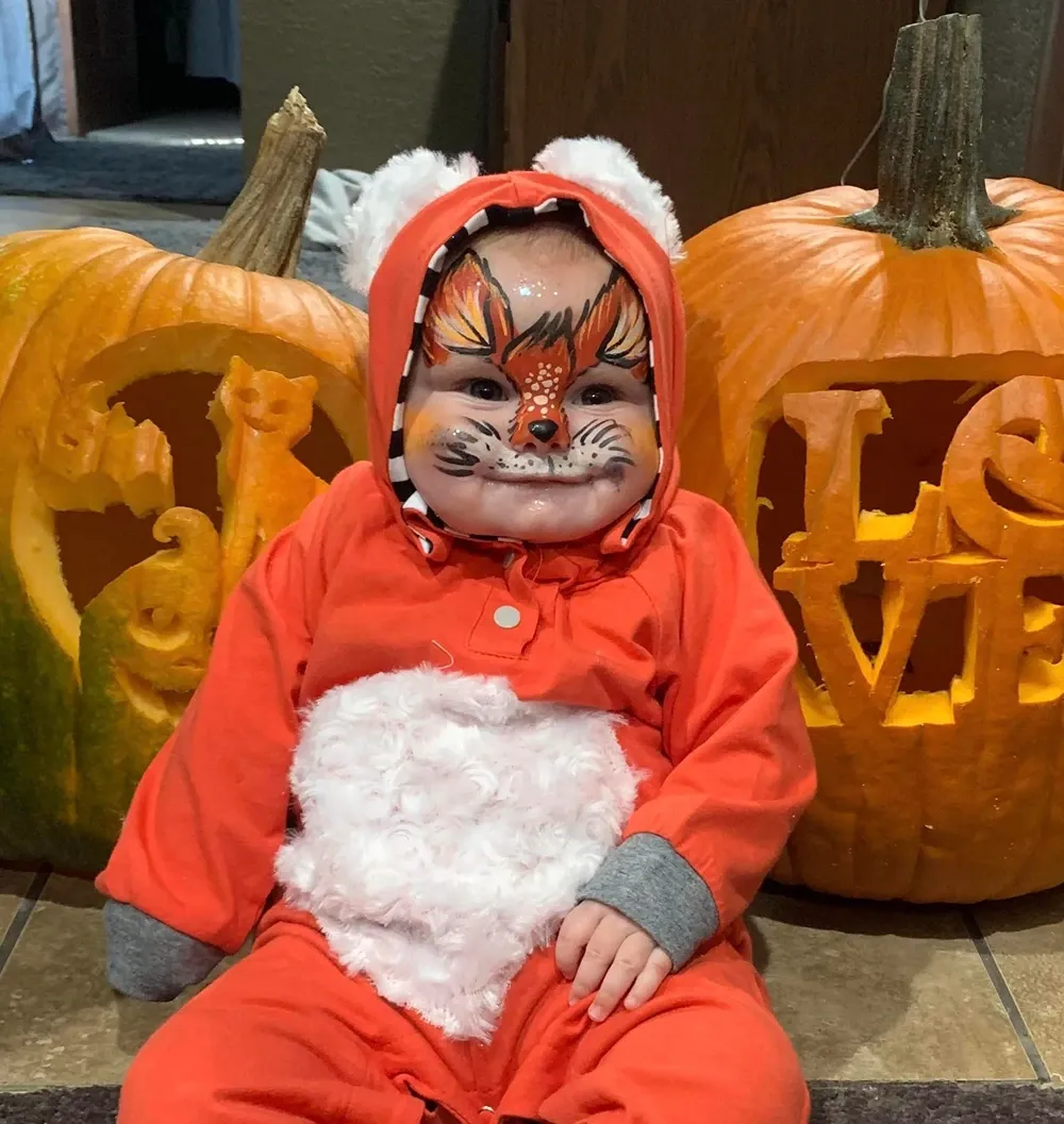 baby with pumpkin halloween face paint