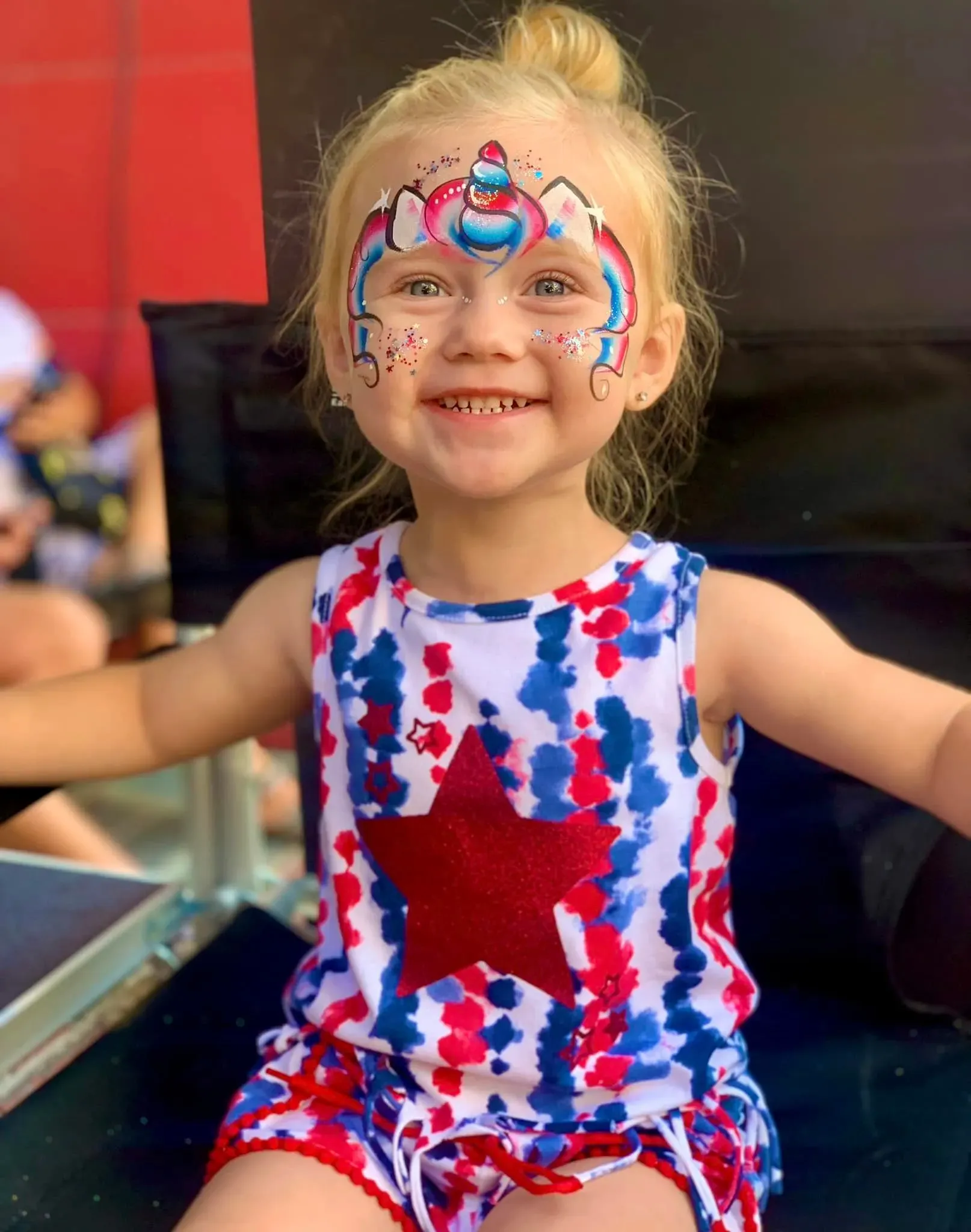 girl with 4th of july rainbow unicorn face paint