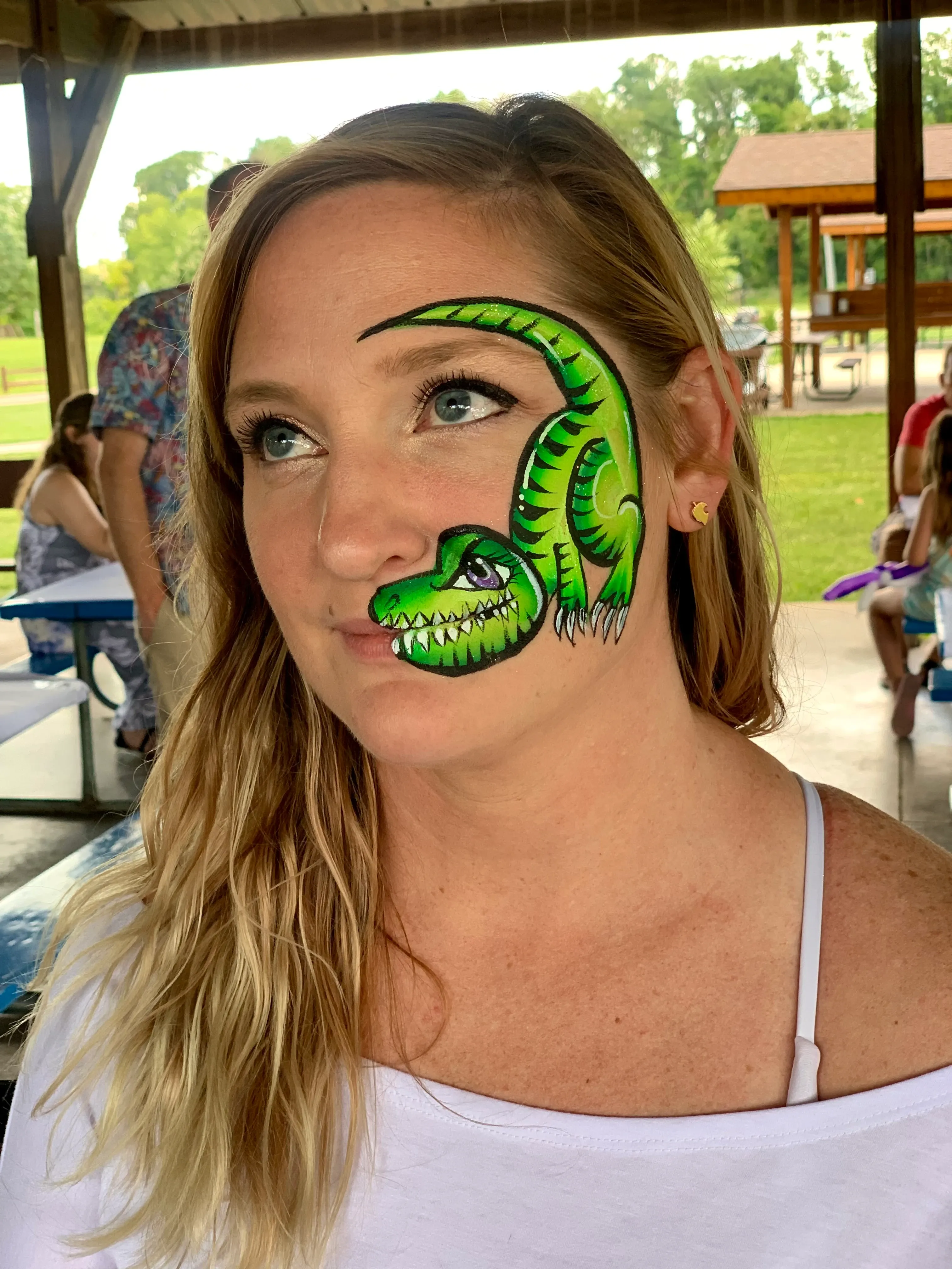 woman with green dinosaur face paint