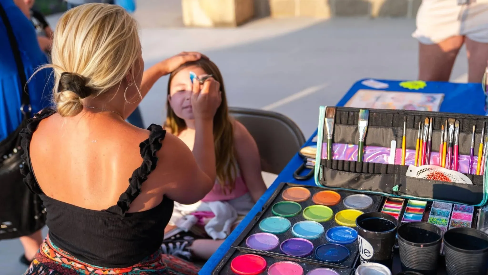 girl getting her face painted at an event